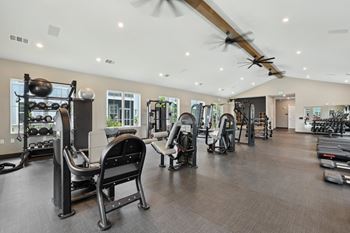 A gym with a variety of equipment including treadmills, weights, and exercise machines.